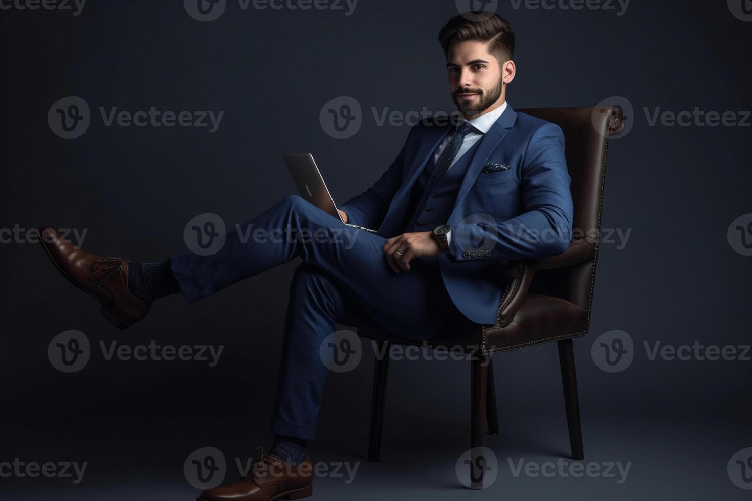 Young businessman sitting on chair and working with laptop on blue background. photo