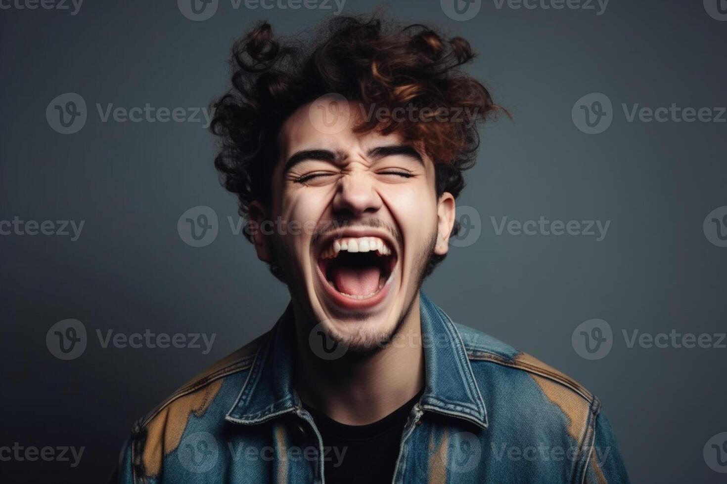 Excited young man celebrating success on dark background photo