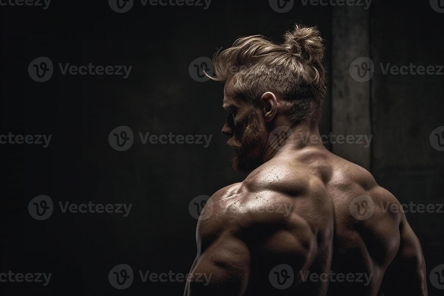 Handsome muscular man posing over black background. Back view photo