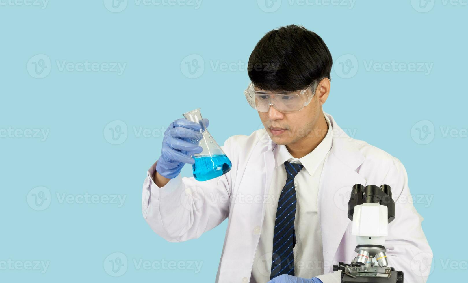 asiático hombre estudiante científico en reactivo mezcla laboratorio en un Ciencias investigación laboratorio con prueba tubos de varios tamaños en el piso en laboratorio química laboratorio azul antecedentes. foto