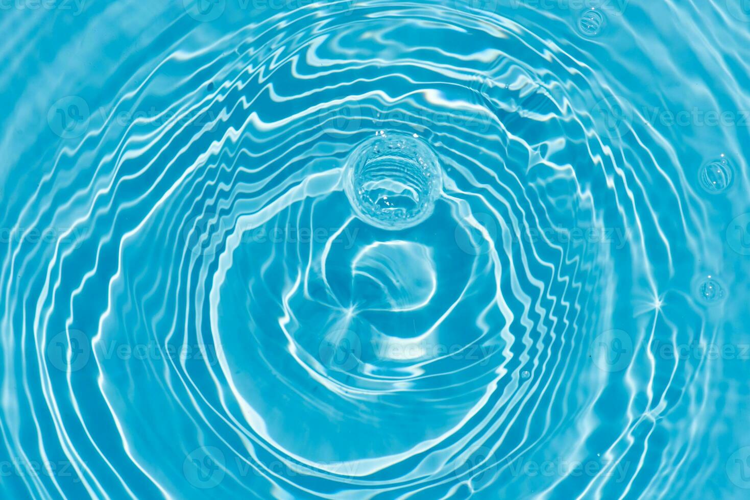 Blue water with ripples on the surface. Defocus blurred transparent blue colored clear calm water surface texture with splashes and bubbles. Water waves with shining pattern texture background. photo