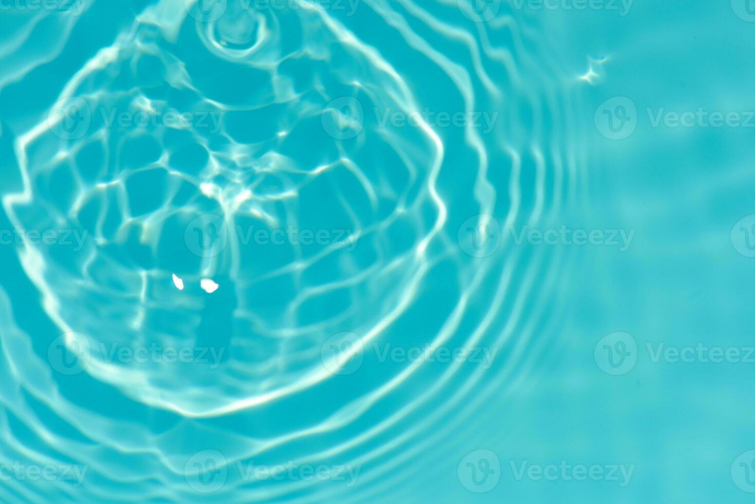 Blue water with ripples on the surface. Defocus blurred transparent blue colored clear calm water surface texture with splashes and bubbles. Water waves with shining pattern texture background. photo