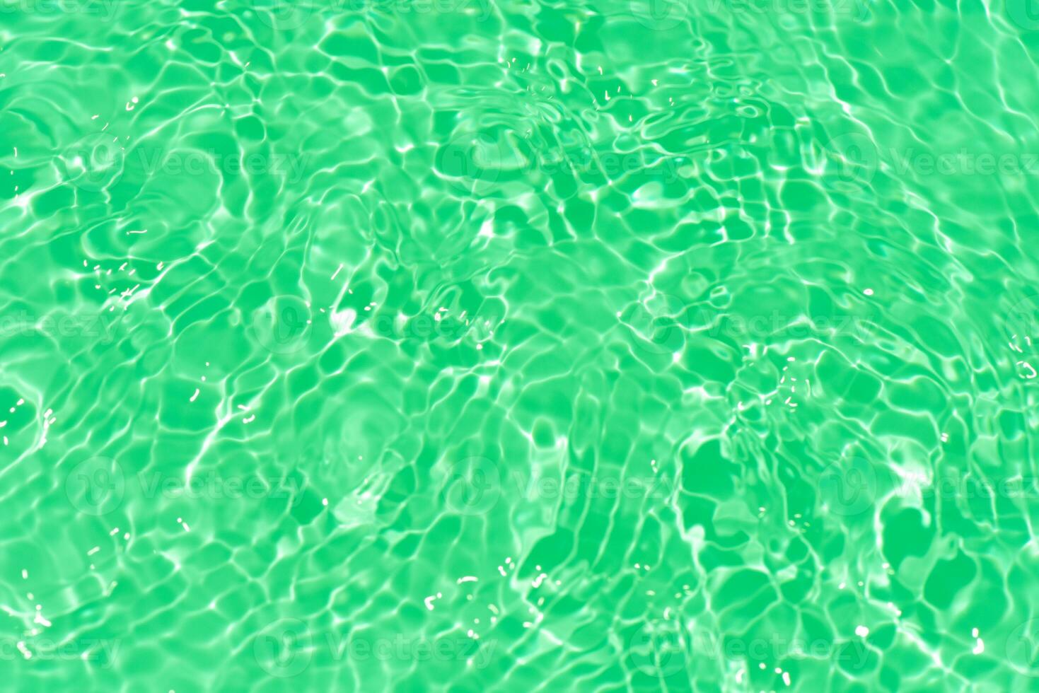 Blue water with ripples on the surface. Defocus blurred transparent blue colored clear calm water surface texture with splashes and bubbles. Water waves with shining pattern texture background. photo