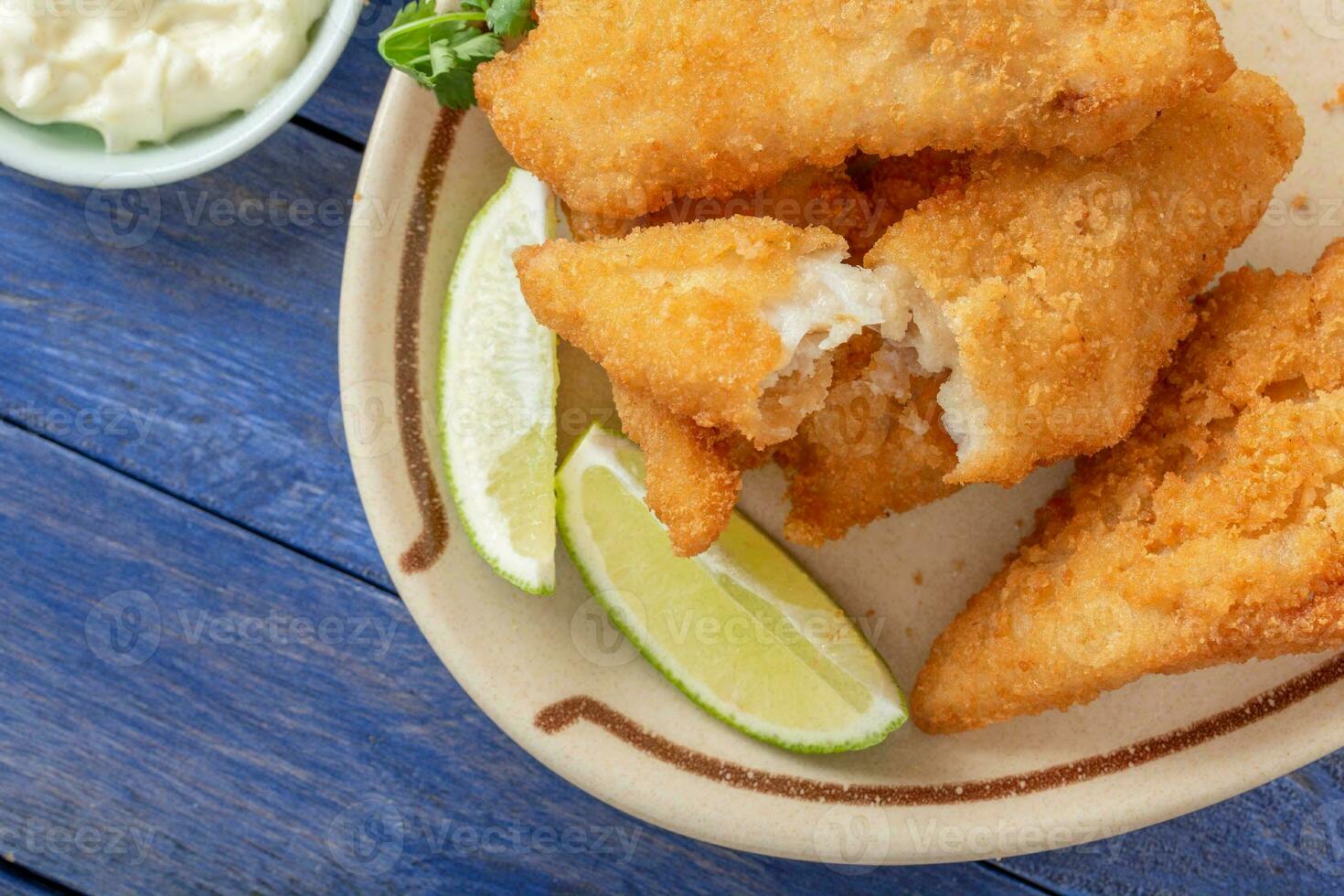 Crispy and Golden CloseUp of Beer Battered Deep Fried Fish with Lemon