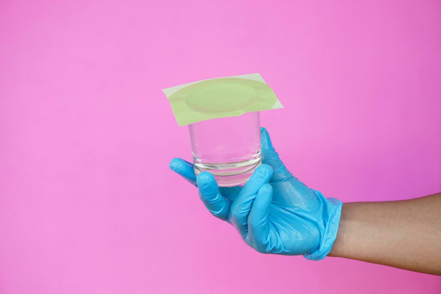 Closeup hand hold and turn up a glass of water, covered the glass with paper. Concept,  science experiment about air and liquid pressure. Easy science subject activity, education. photo