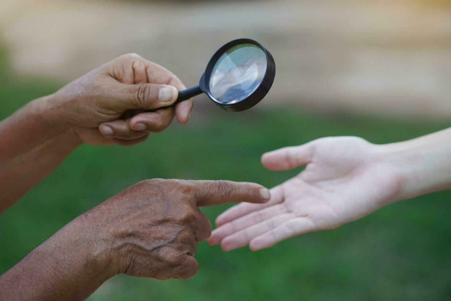 la mano de primer plano sostiene una lupa para inspeccionar las líneas de la palma. concepto, quiromancia, astrología. adivinación, misterio, magia, fortuna, destino. predicción para la vida futura, eventos. predicción palmista. foto