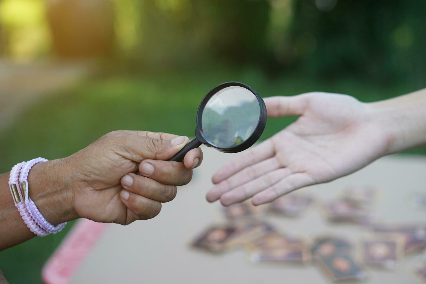 la mano de primer plano sostiene una lupa para inspeccionar las líneas de la palma. concepto, quiromancia, astrología. adivinación, misterio, magia, fortuna, destino. predicción para la vida futura, eventos. predicción palmista. foto