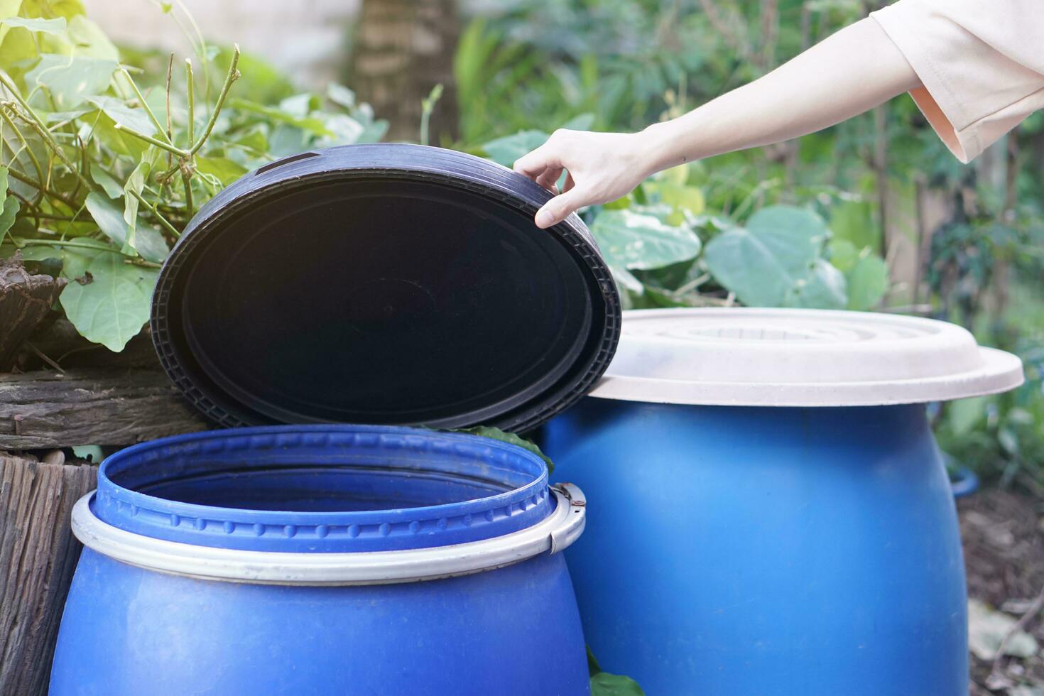 Closeup hand hold lid to cover water bucket to protect from mosquito to breed inside or other  insects or dust go into water. Concept, campaign to stop mosquitoes cycle to lay eggs in water container photo