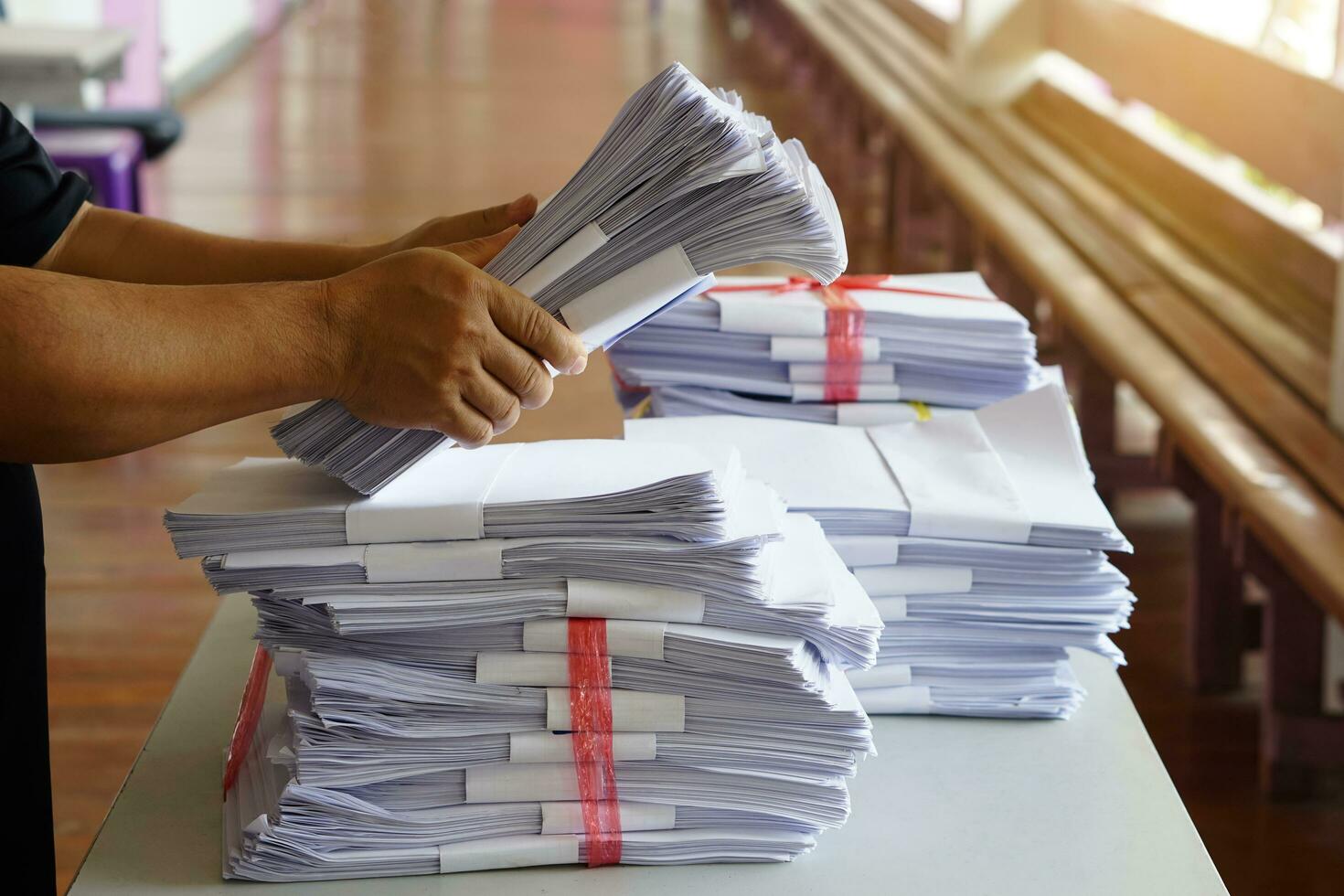 Closeup hands hold stack of used paper, combine to use next time or take to recycle process. Concept, eco friendly activity. Waste paper management. Reduce reuse, recycle paper. photo