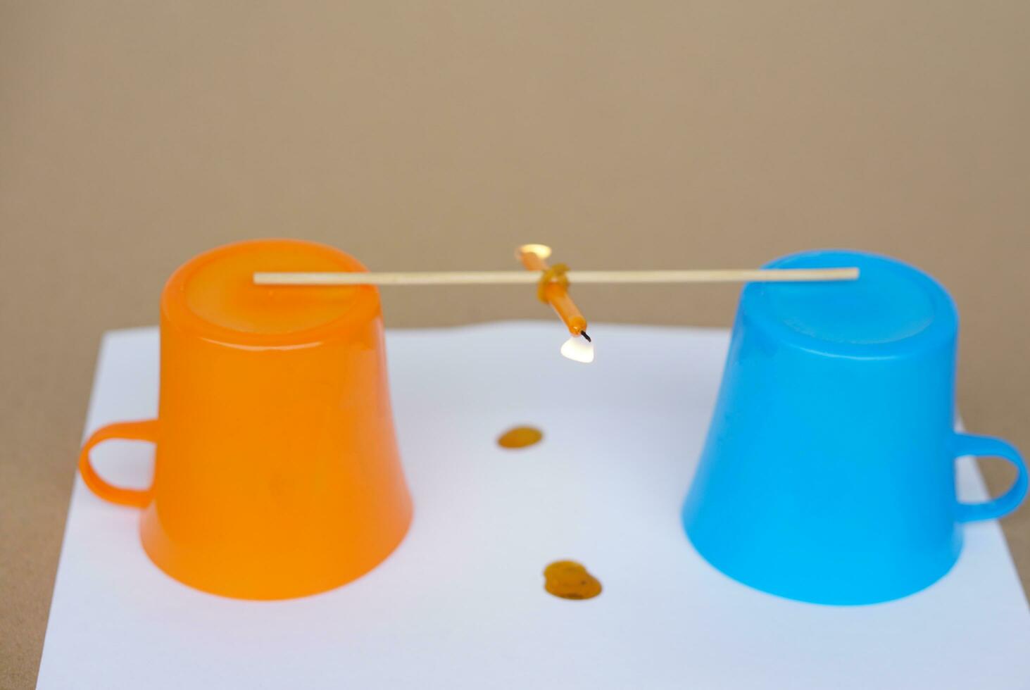 Science experiment about weight balance of burning candle. Concept, Science subject lesson, Weight balance. Fun and easy experiment activity for kids. Candle seesaw. Learning by doing. Education. photo