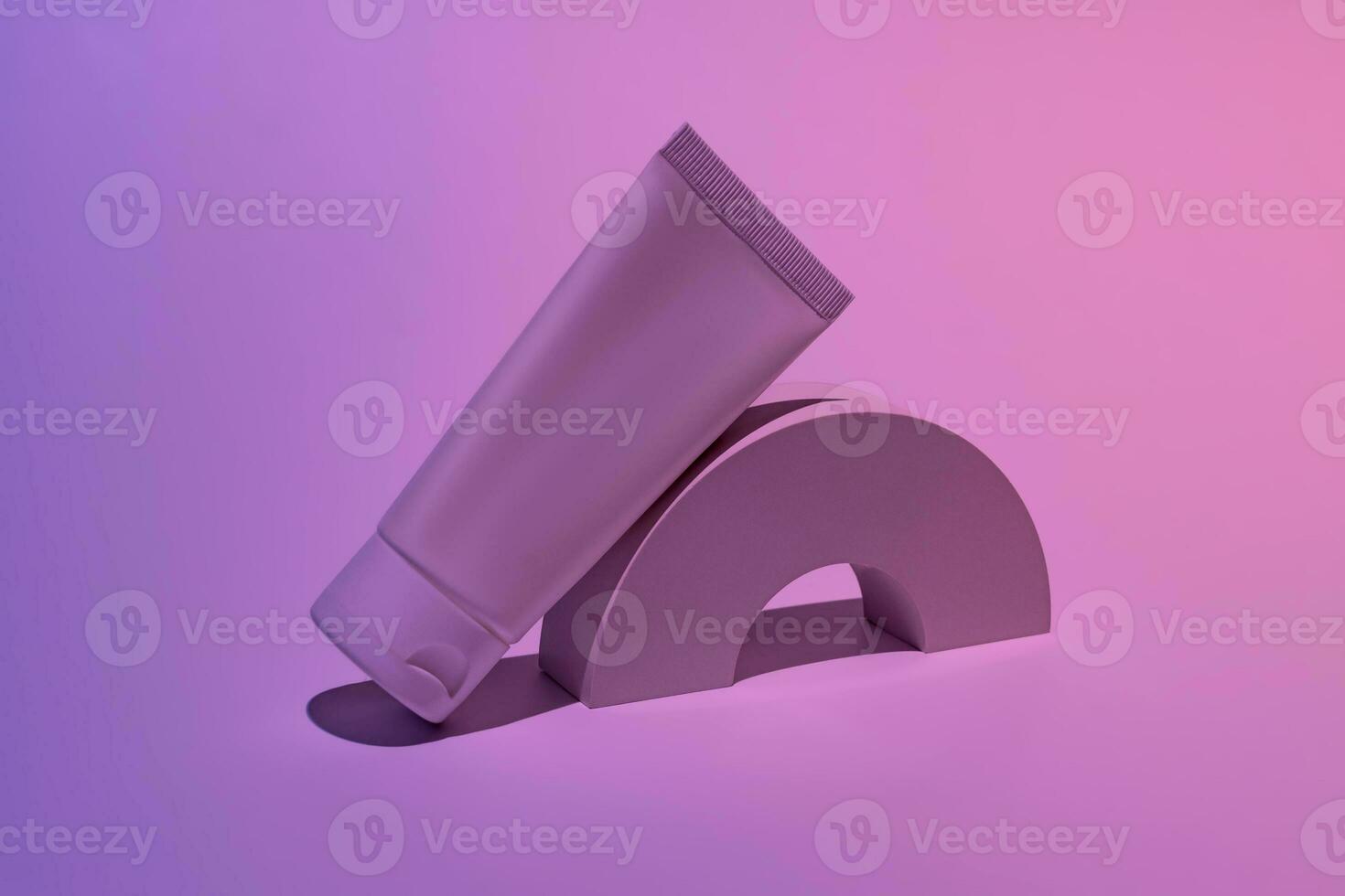 White cosmetic tube mockup. Plastic packaging for cosmetology cream product on a white podium on neon blue and pink background. Skincare concept photo