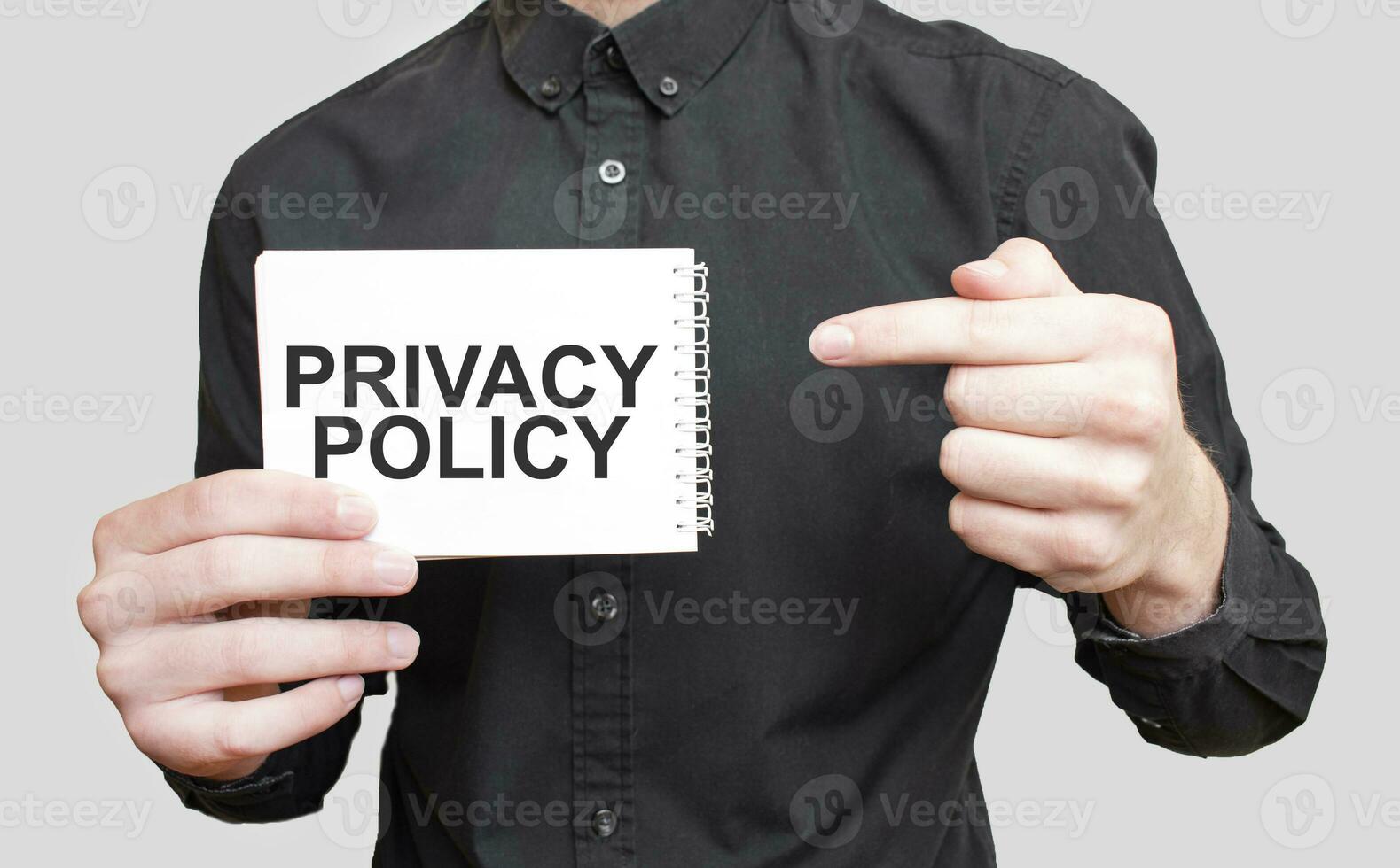 Businessman holding a white notepad with text PRIVACY POLICY , business concept photo