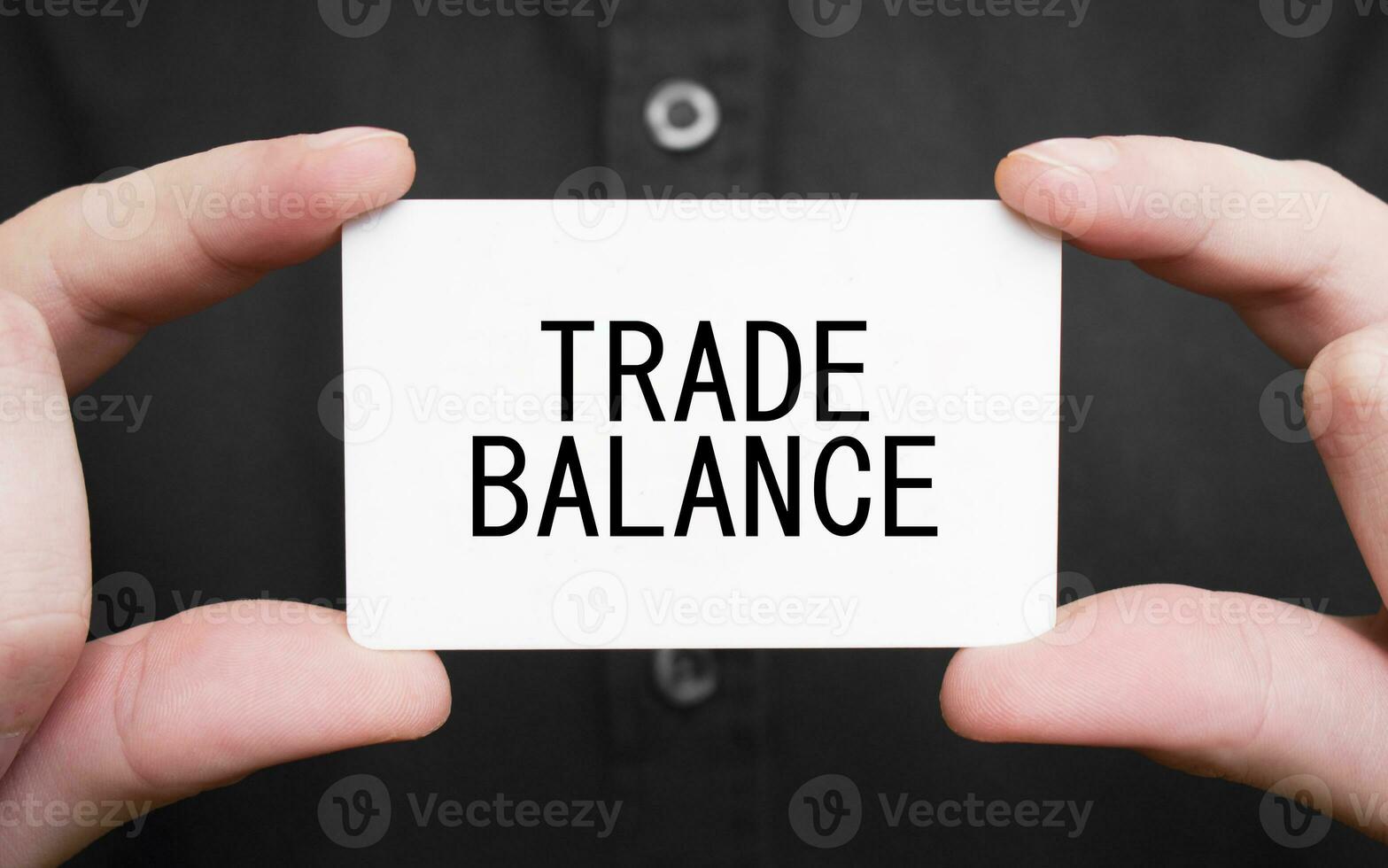 Businessman holding a card with text TRADE BALANCE, business concept photo