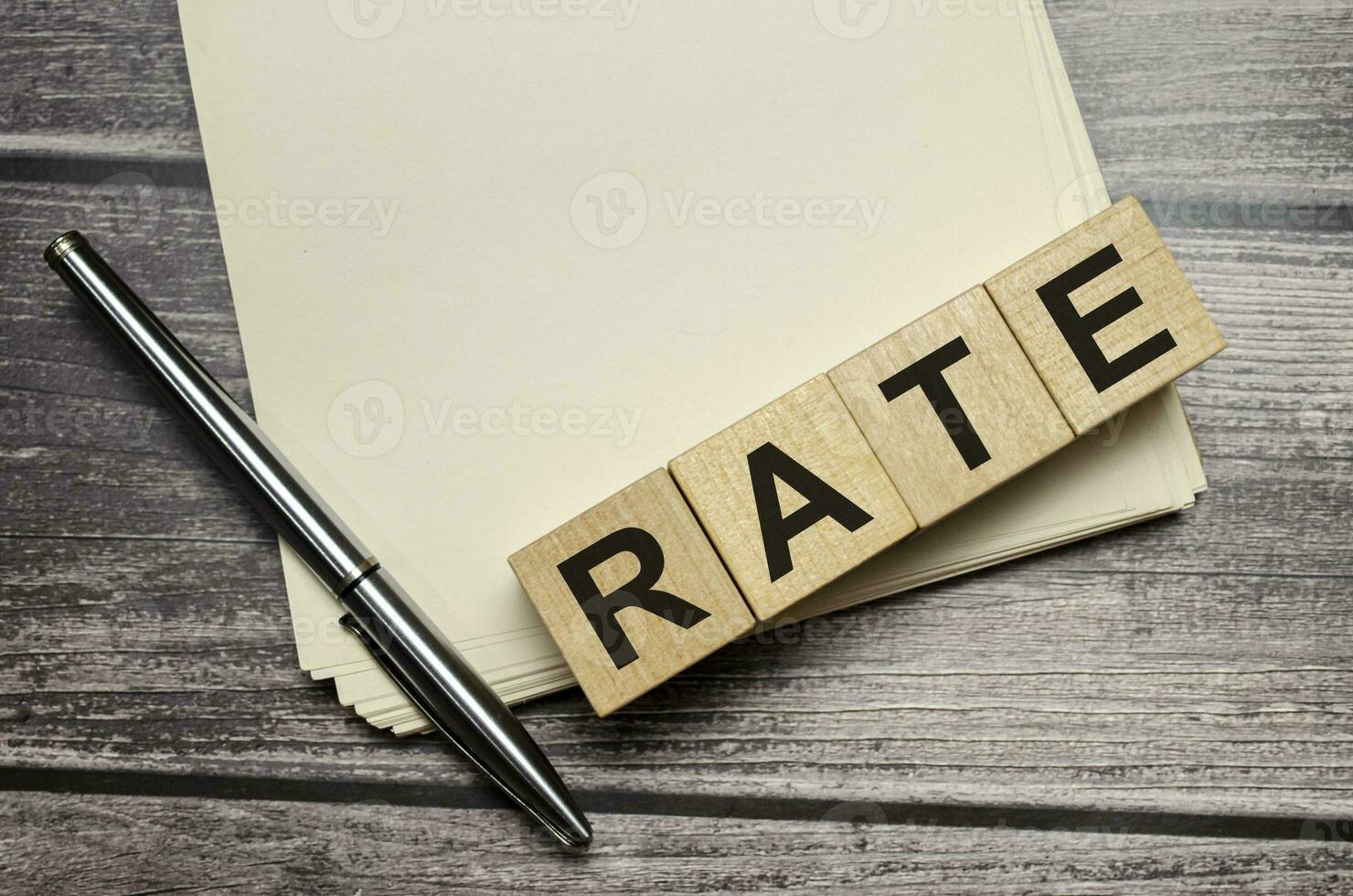 rate Word Written In Wooden Cubes on notebook with pen photo