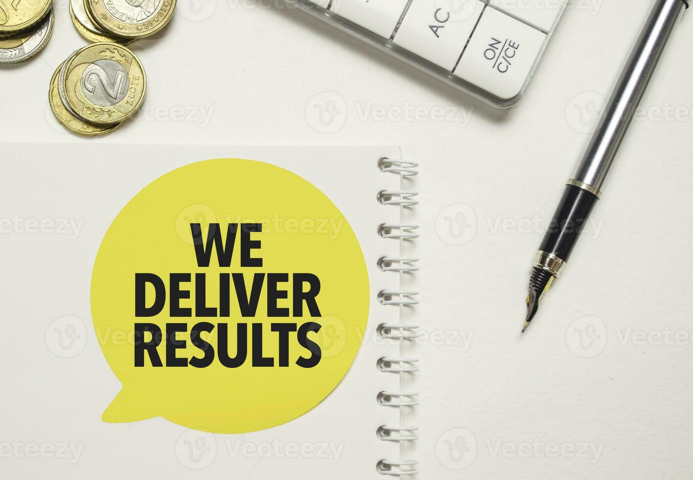 we deliver results words on yellow sticker with calculator and pen photo