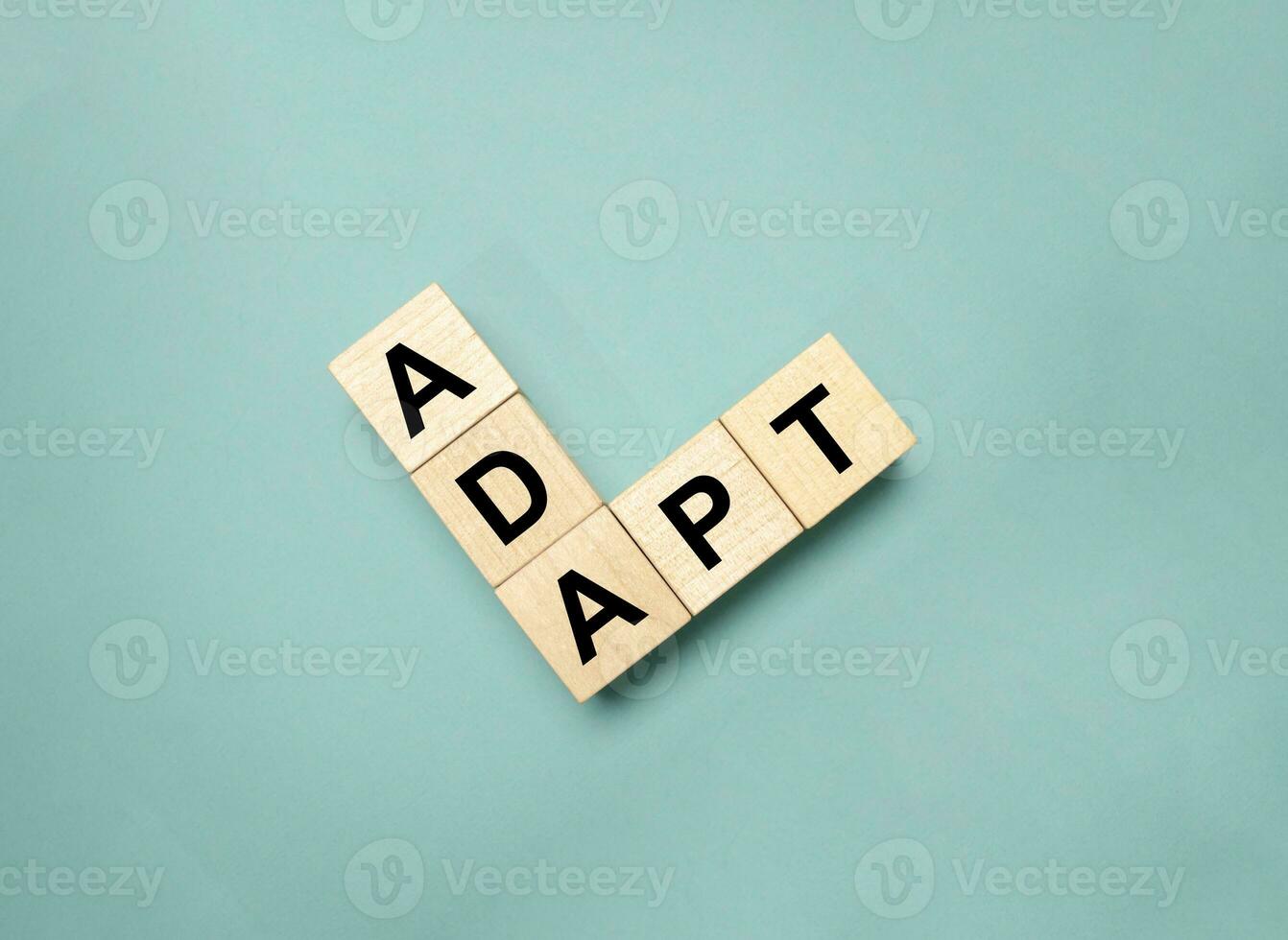 word adapt on wooden cubes with green background photo