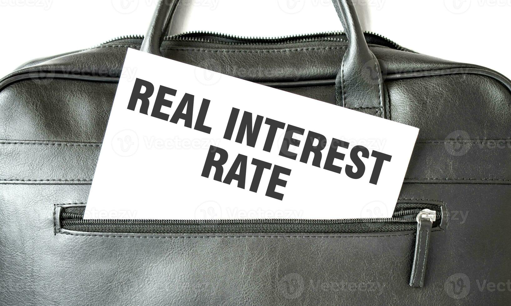 Text REAL INTEREST RATE writing on white paper sheet in the black business bag. Business concept photo