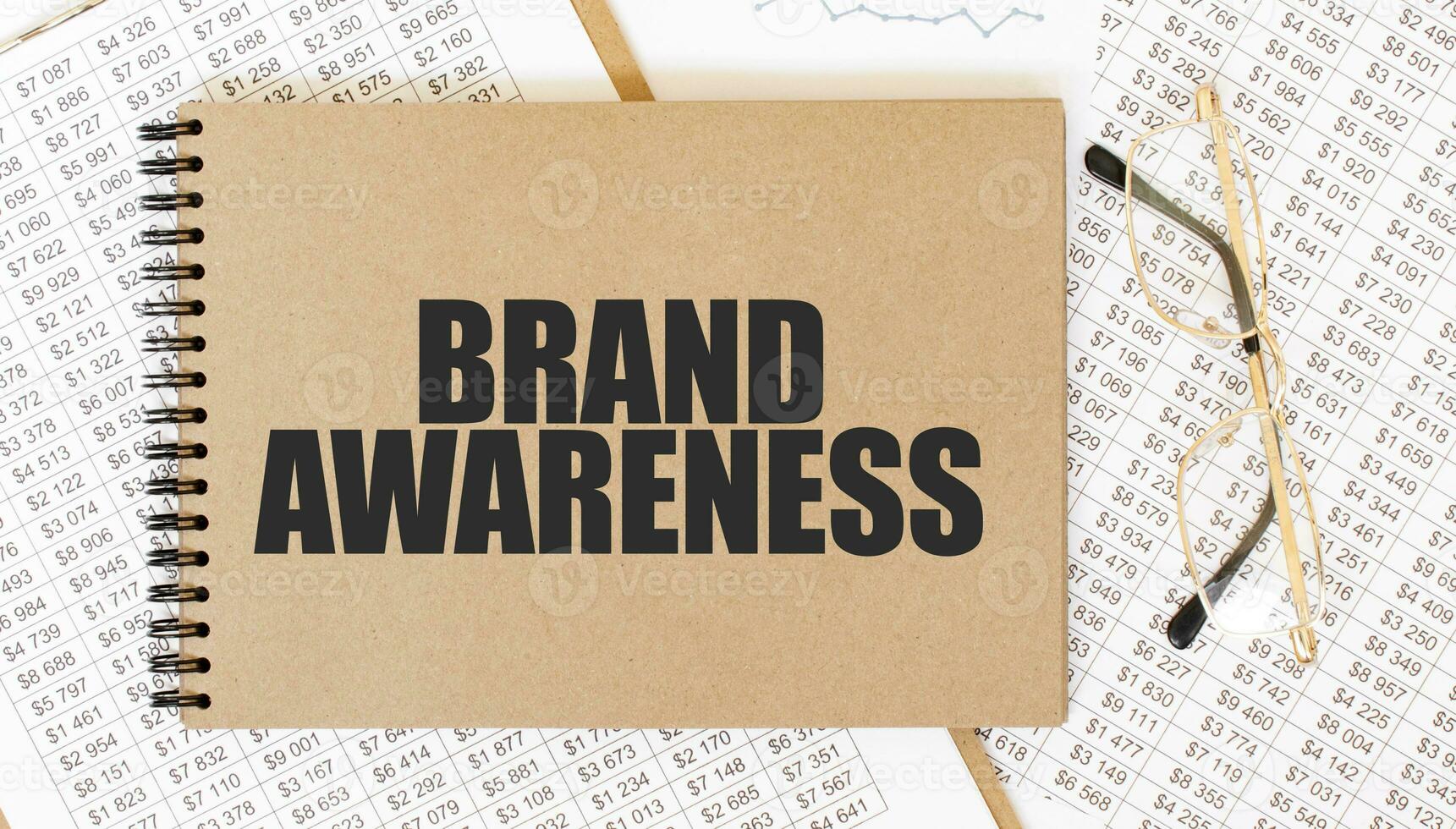 Craft colour notepad with text BRAND AWARENESS. Notepad with eyeglasses and text documents. Business concept photo