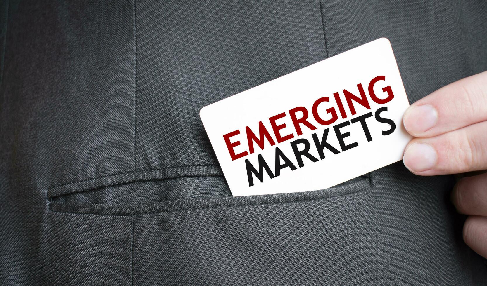 tarjeta con emergente mercados texto en bolsillo de empresario traje. inversión y decisiones negocio concepto. foto