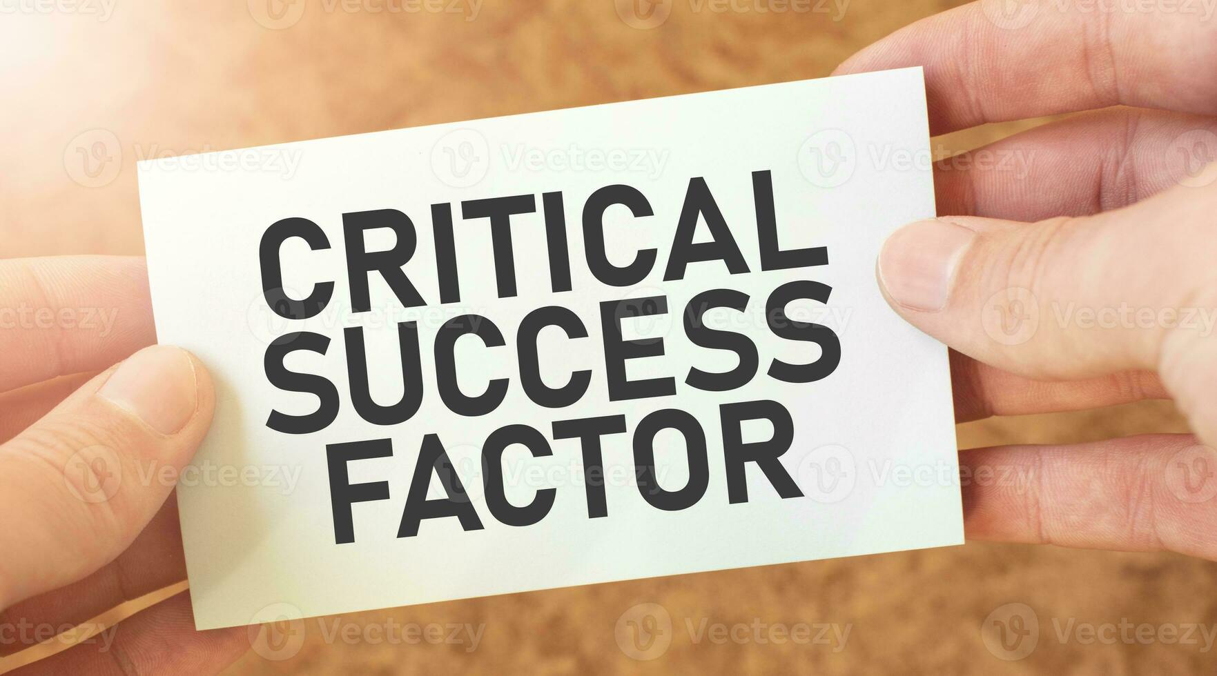 CRITICAL SUCCESS FACTOR word inscription on white card paper sheet in hands of a businessman. recap concept. red and white paper photo