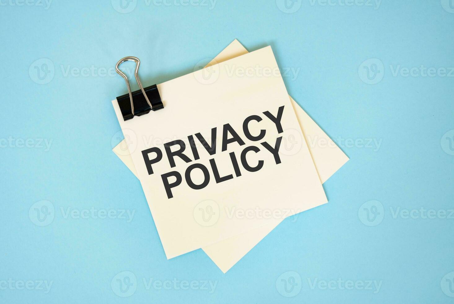 Text PRIVACY POLICY on sticky notes with copy space and paper clip isolated on red background.Finance and economics concept. photo
