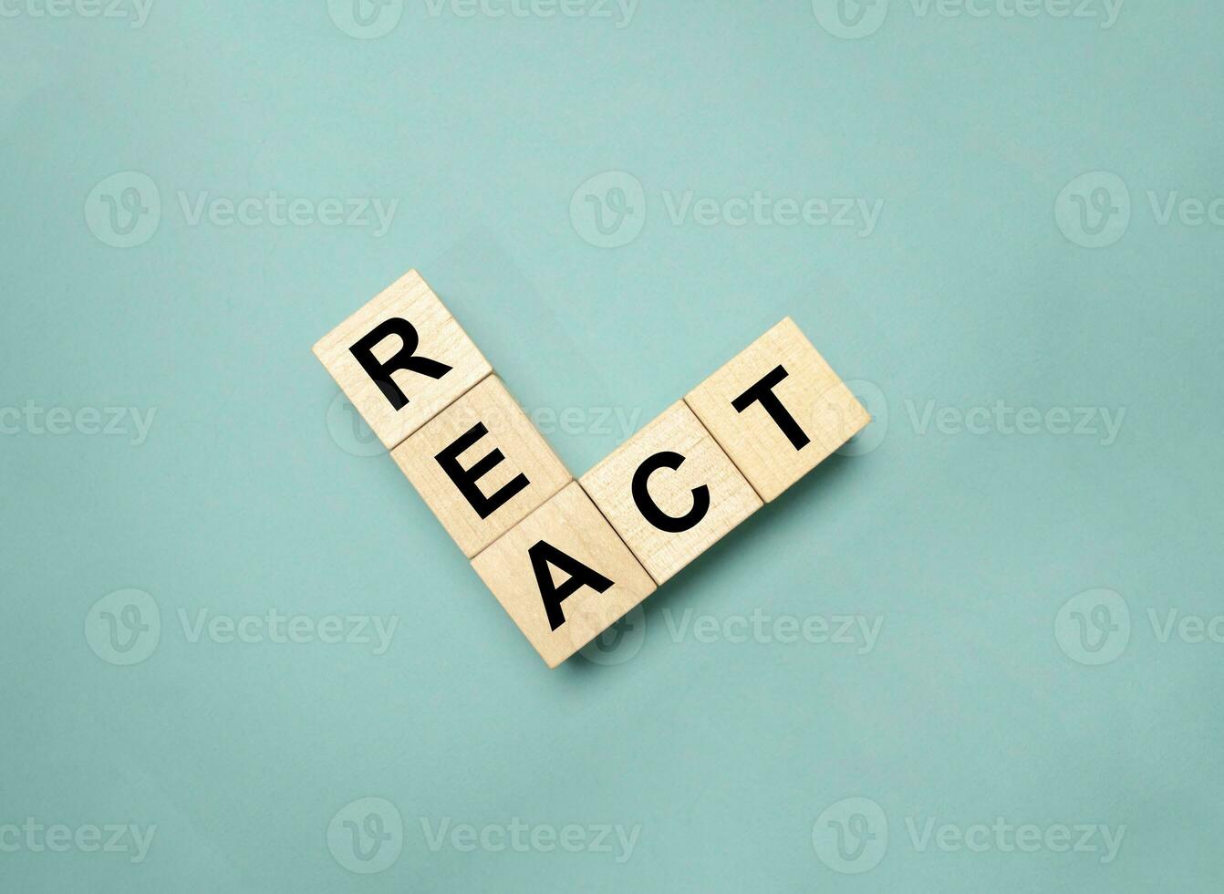 Word REACT on wooden blocks and green background photo