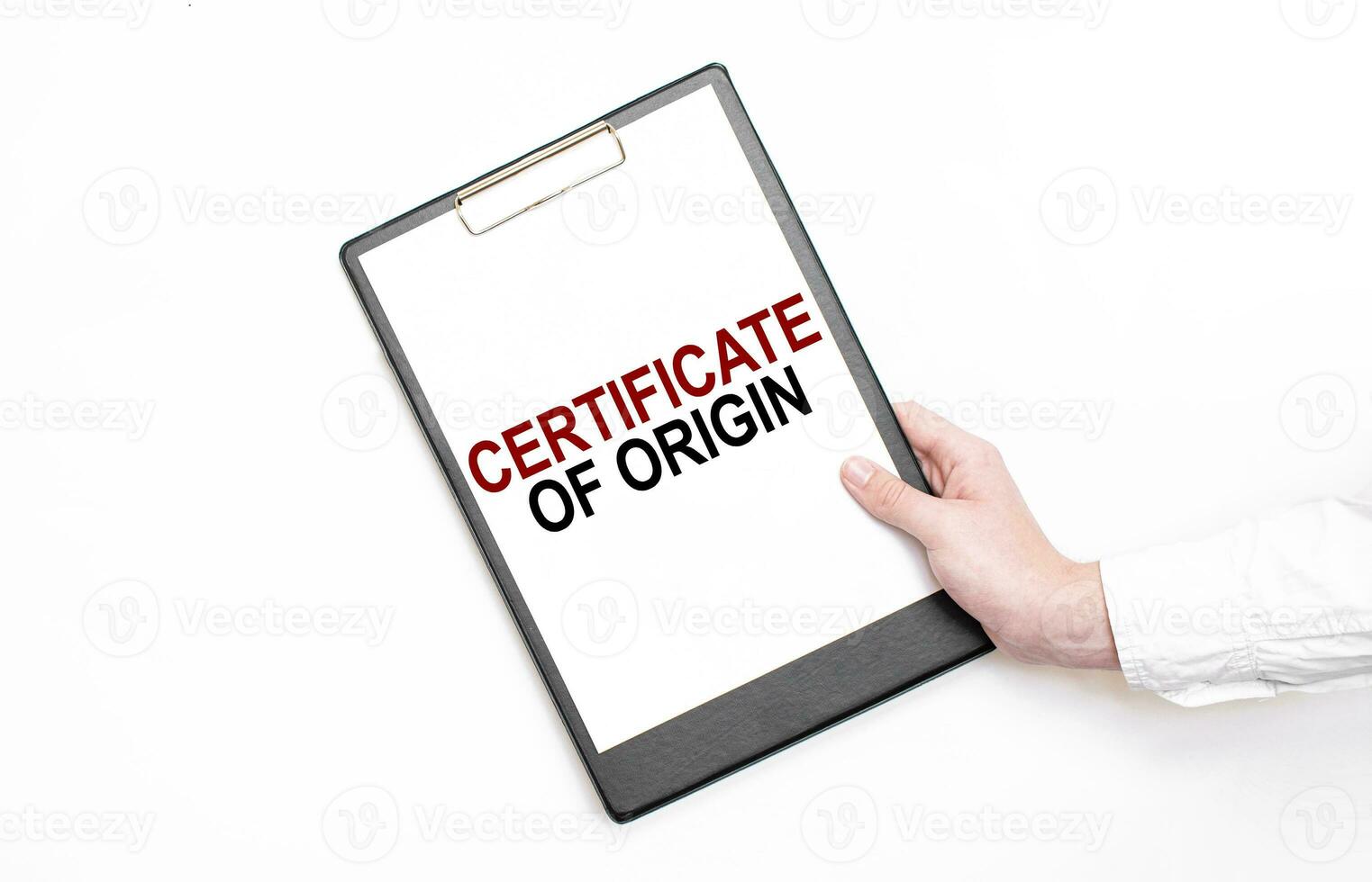 A businessman holds a folder with paper sheet with the text CERTIFICATE OF ORIGIN. Business concept. photo