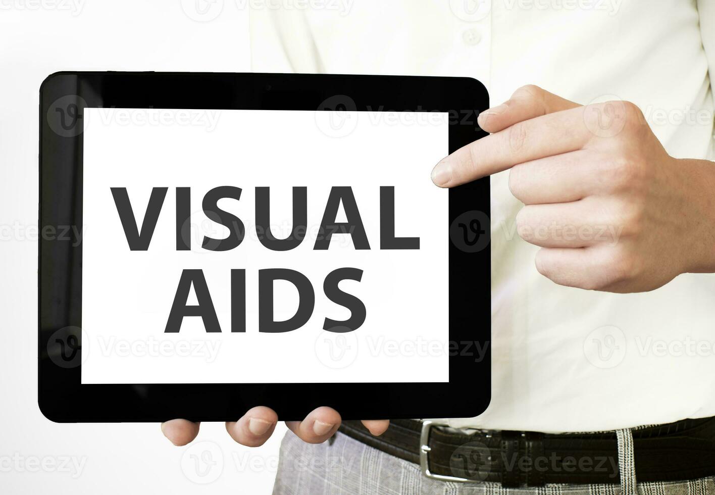 Text VISUAL AIDS on tablet display in businessman hands on the white ...
