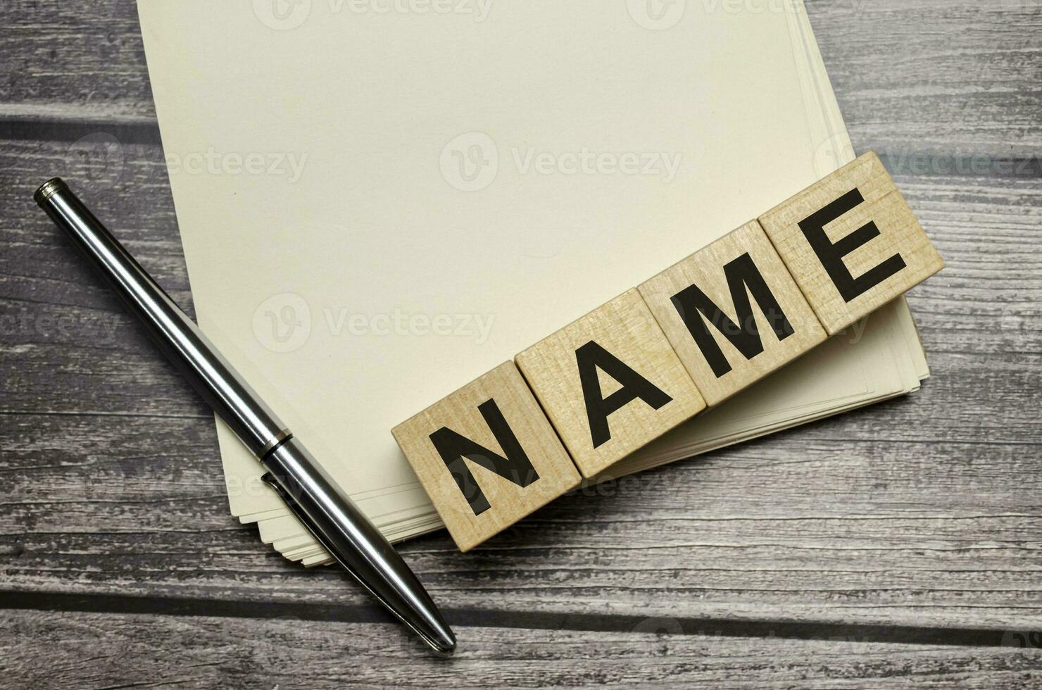 Word NAME on notebook with pen on brown background photo