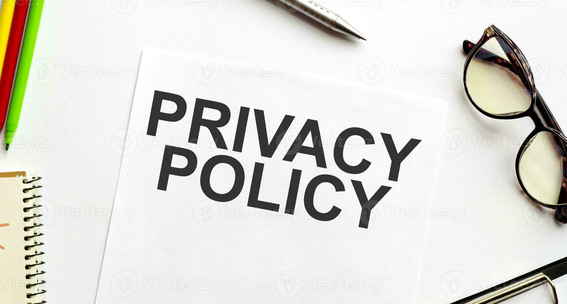 PRIVACY POLICY on paper sheet with glasses and pencils photo