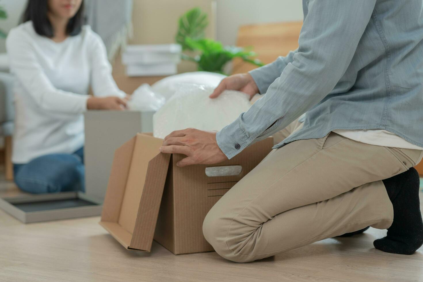 Moving house, relocation. Couple help set and move furniture for new apartment, inside the room was a cardboard box contain personal belongings. move in the new apartment or condominium photo