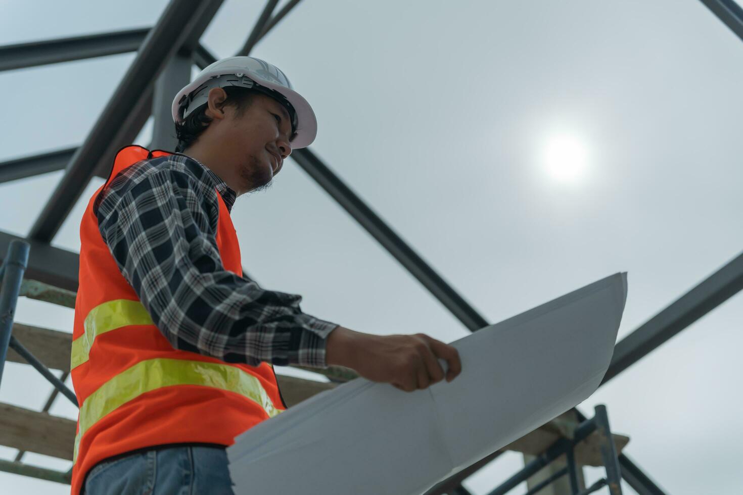 inspector or engineer is inspecting construction and quality assurance new house using a blue print. Engineer or architects or contactor work to build the house before handing it over to the homeowner photo