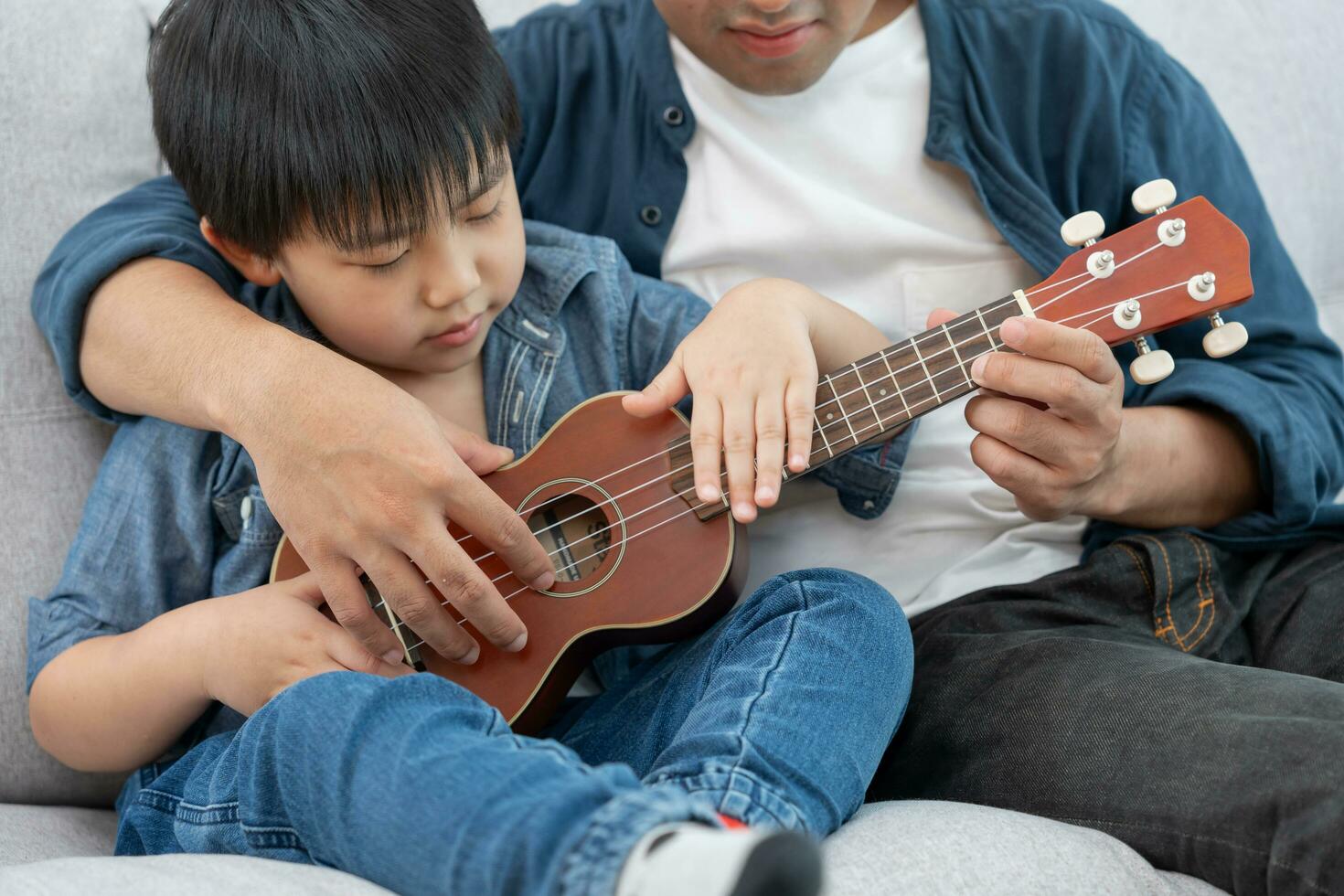 contento soltero padre jugando aprendizaje música con el pequeño chico. gracioso familia es contento y emocionado en el casa. padre y hijo teniendo divertido gasto hora juntos. vacante tiempo, fiesta foto