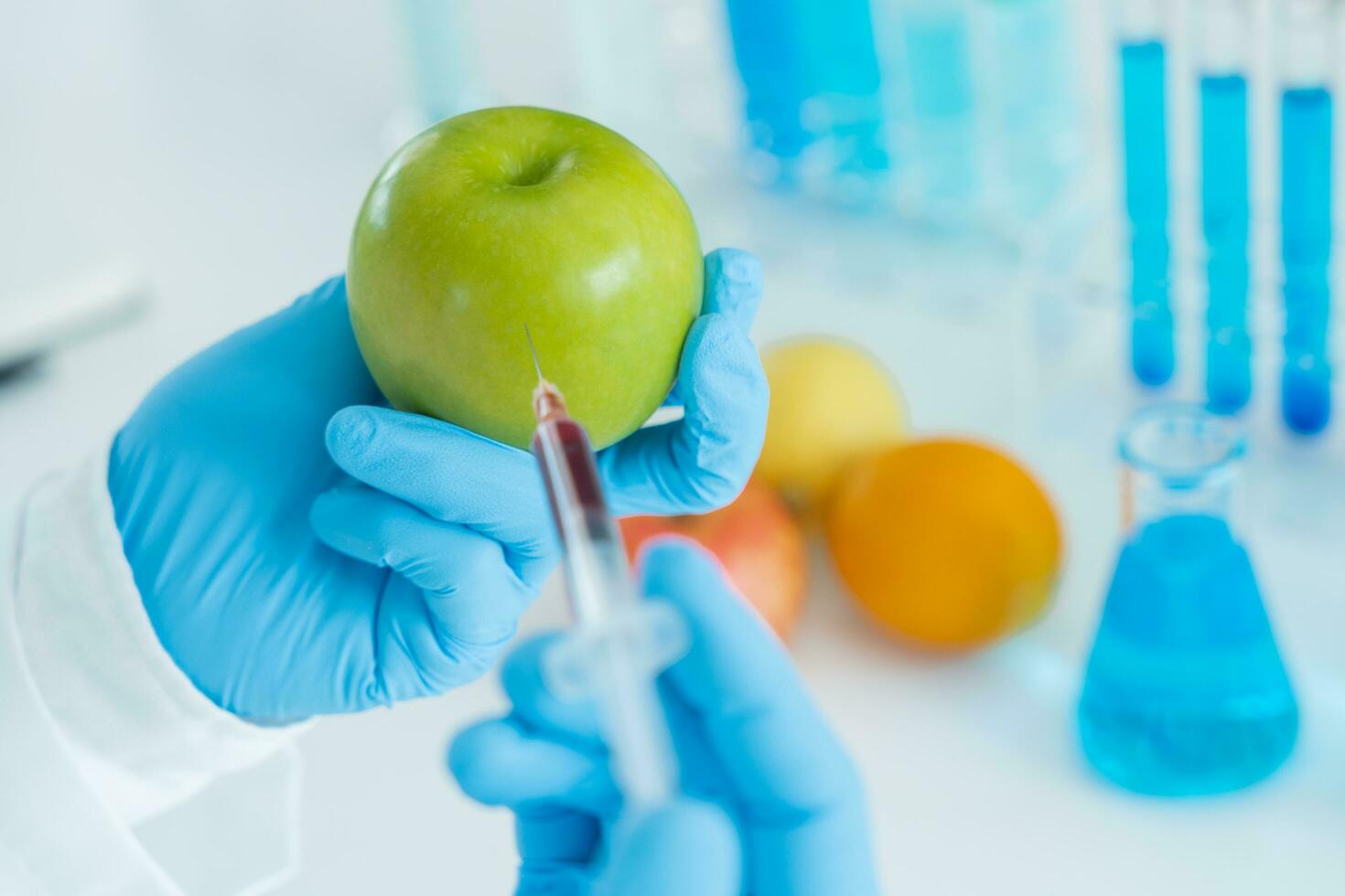 Scientist check chemical food residues in laboratory. Control experts inspect quality of fruit, scientists inject chemicals into apples for experiments, hazards, prohibited substance, contaminate photo