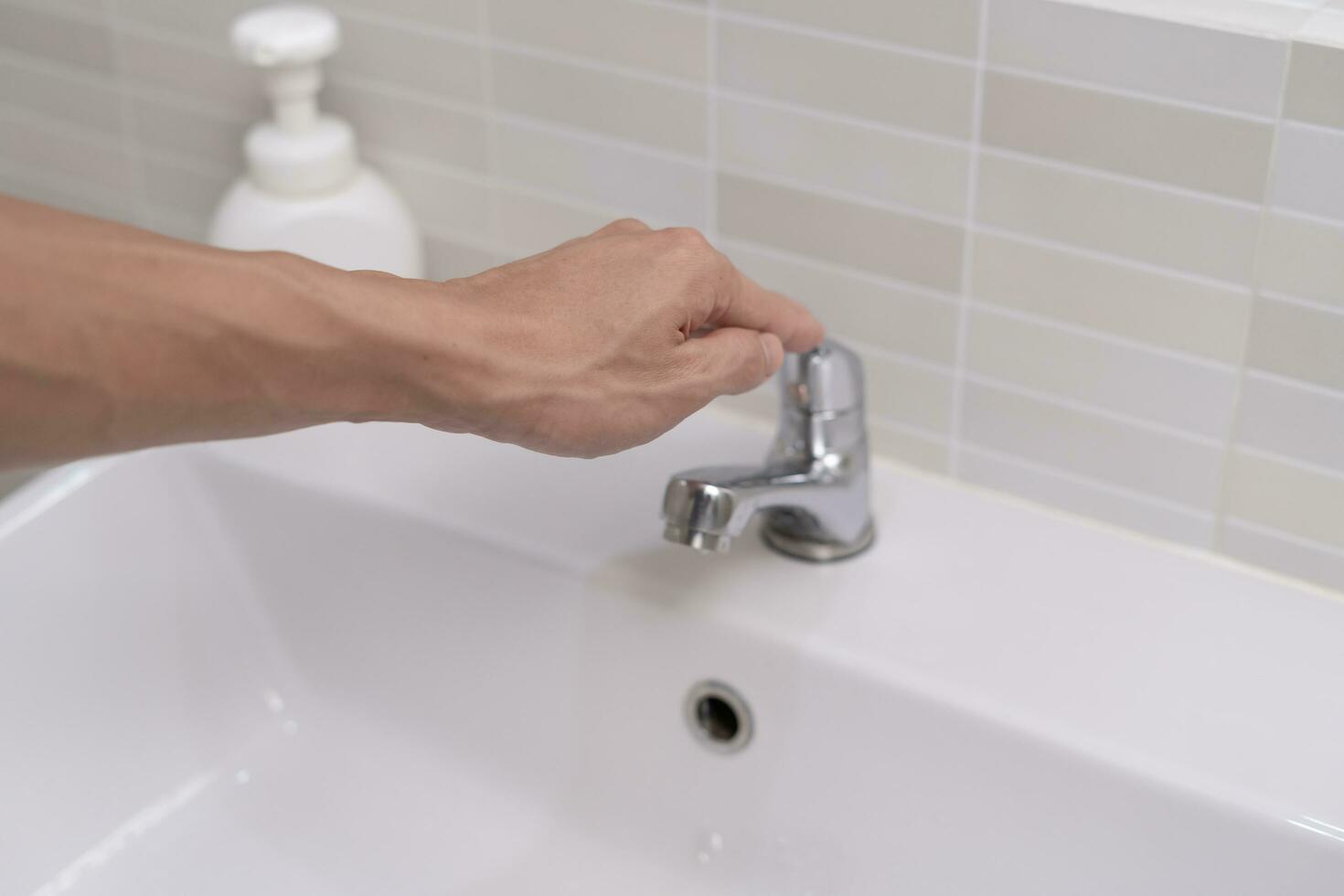 Save water. Man keeps turning off the running water in the bathroom to protect environment. Greening planet, reduce global warming, Save world, life, future, risk energy, crisis , water day. photo