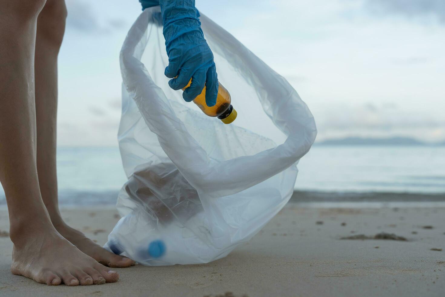 Save water. Volunteer pick up trash garbage at the beach and plastic bottles are difficult decompose prevent harm aquatic life. Earth, Environment, Greening planet, reduce global warming, Save world photo