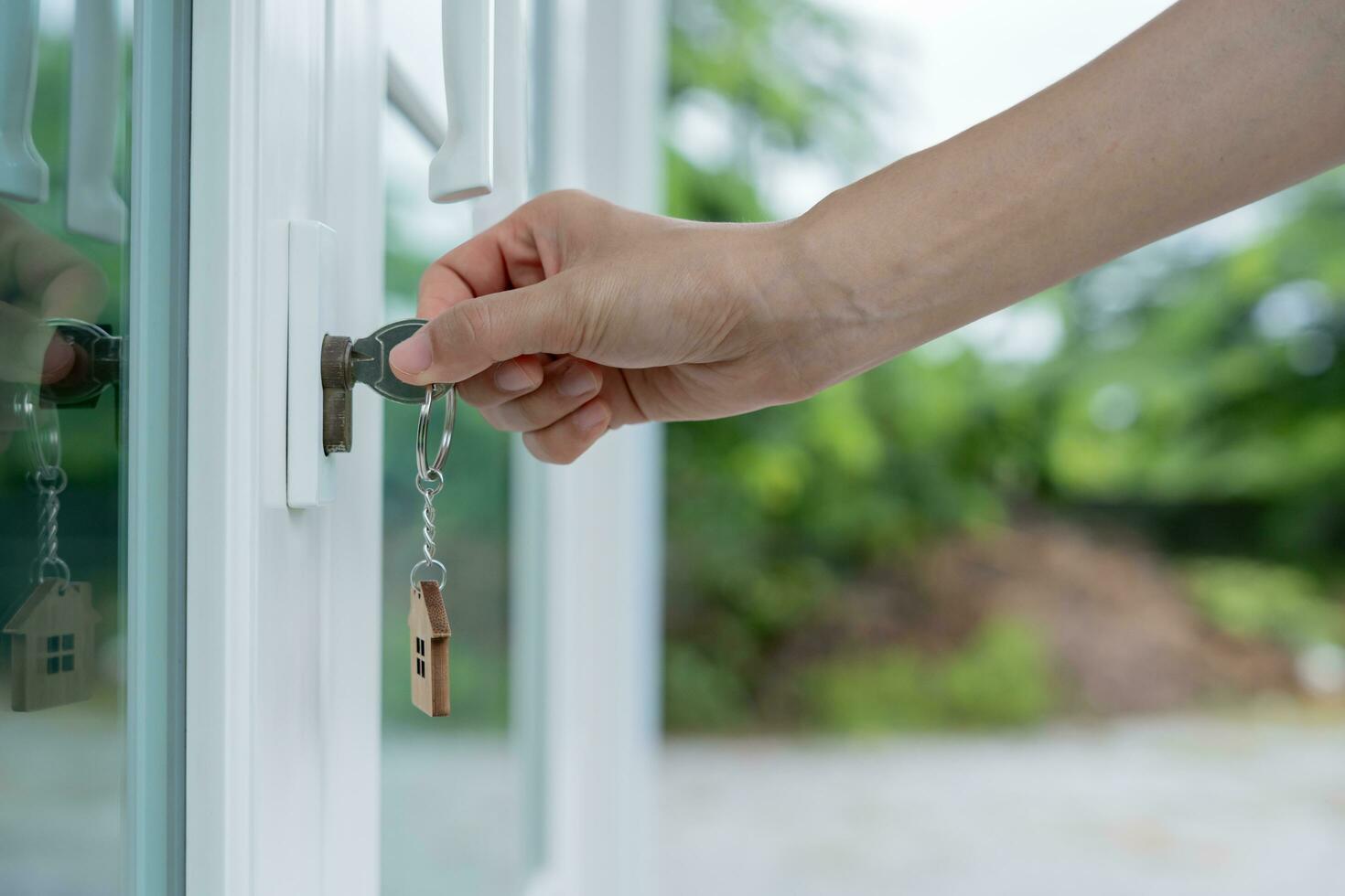 Landlord key for unlocking house is plugged into the door. Second hand house for rent and sale. Owner use hand unlock door mortgage for new home, buy, sell, renovate, investment, owner, estate photo