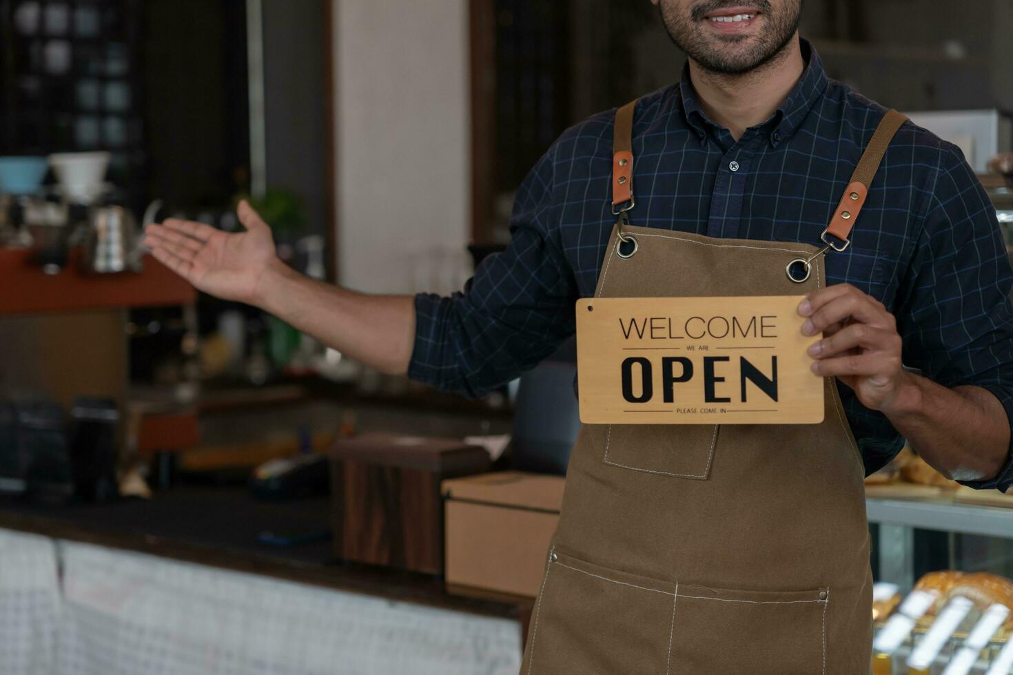 Business man owner show sign open on the first day of business. guarantees safety, cleanliness, open the coffee shop. open for New normal. Small business, welcome, restaurant, home made photo