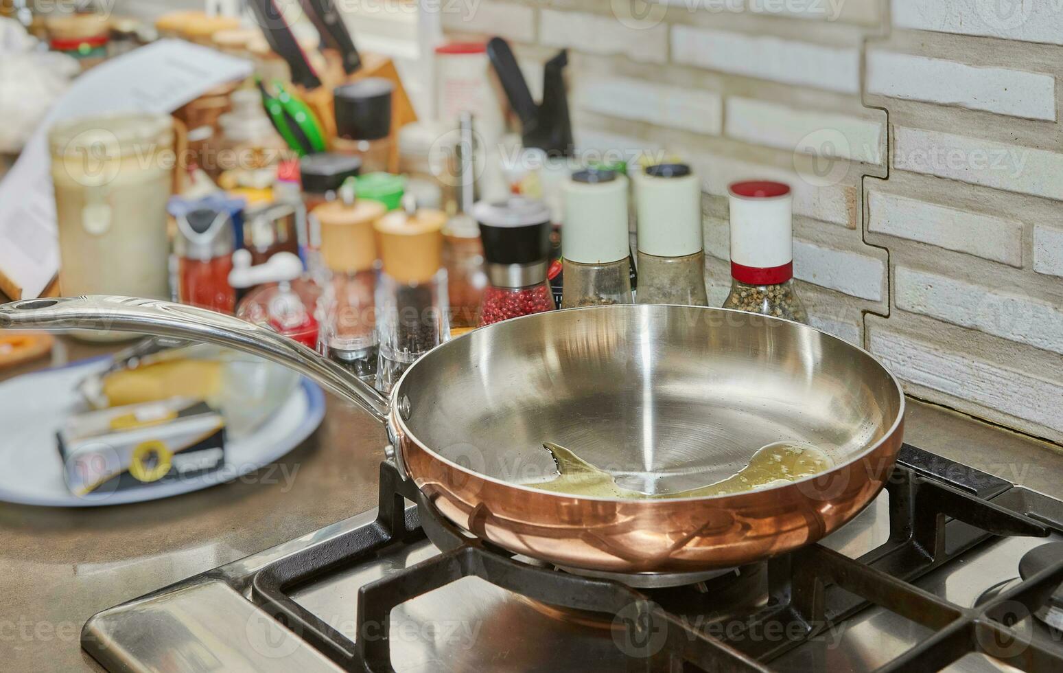 Sunflower oil in copper pan on gas stove photo