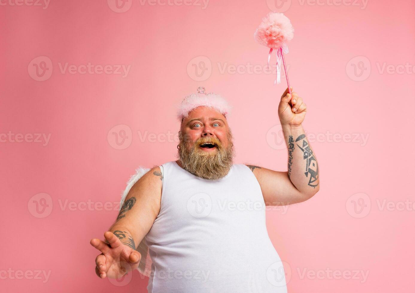 Fat man with tattoos and beard acts like a magic fairy photo