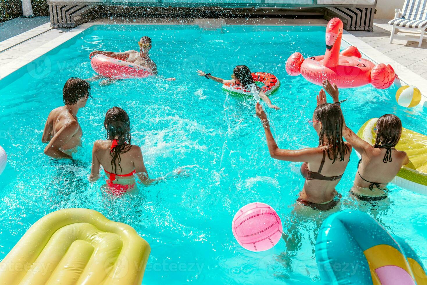 grupo de amigo jugar juntos en el nadando piscina foto