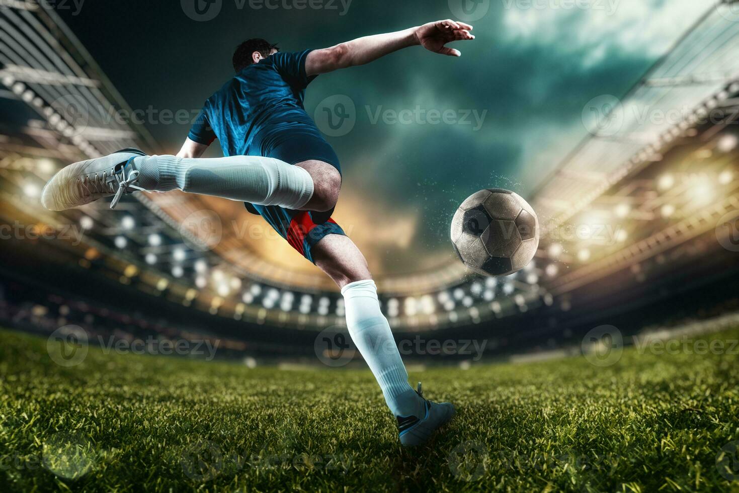 Football scene at night match with player kicking the ball with power photo