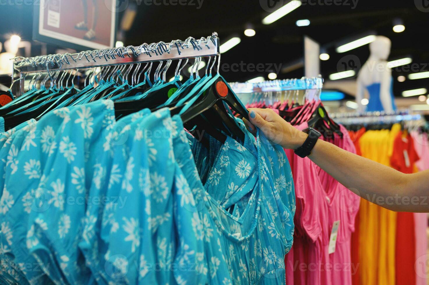 Woman selects a woman dress in a store photo