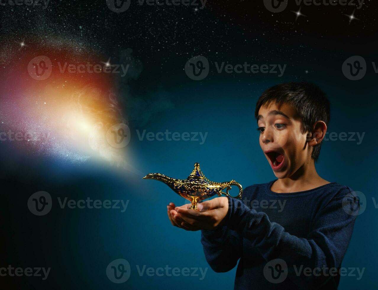 Amazed child with magic Aladin lamp in hand photo
