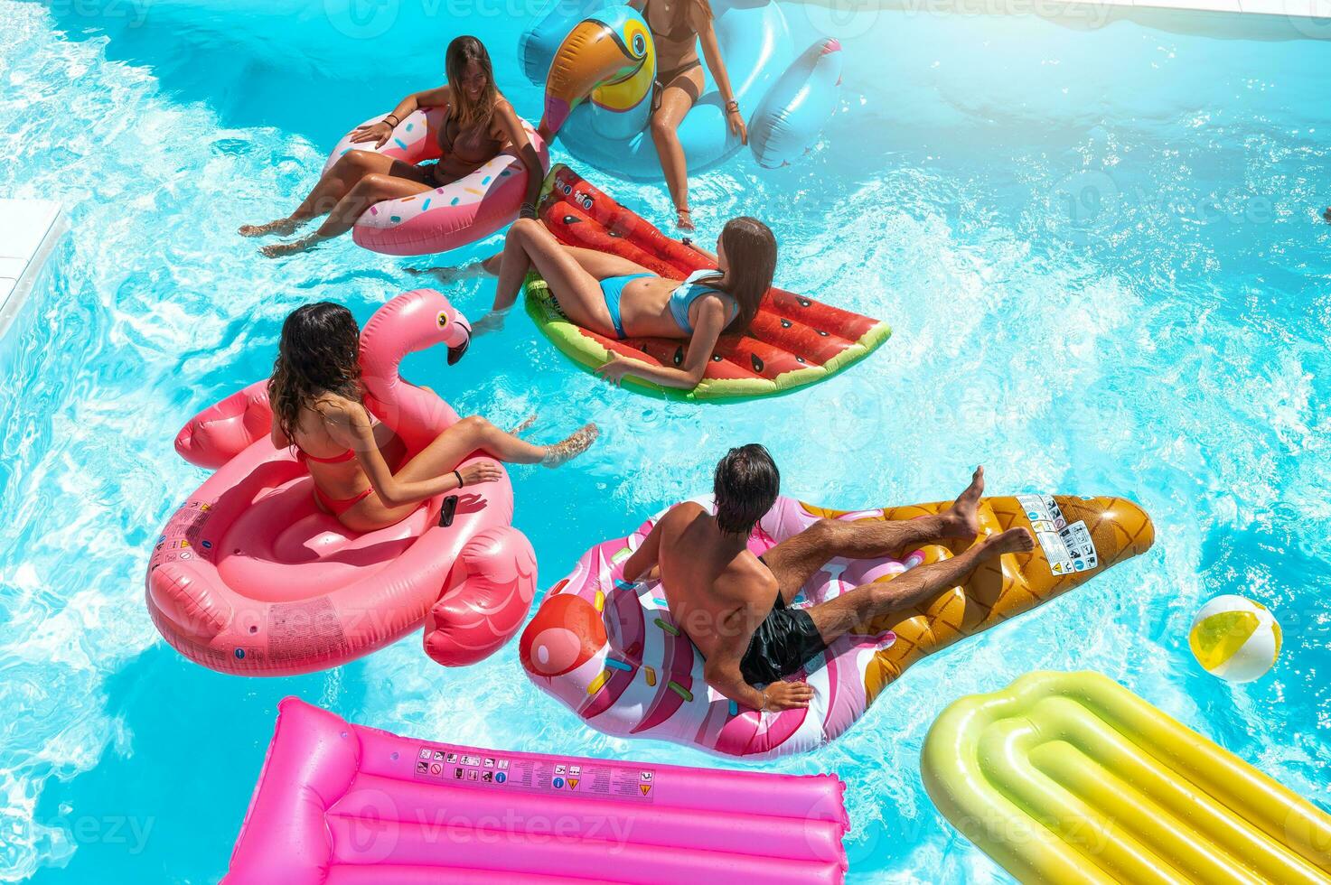 Friends in swimsuit in the pool getting a tan photo