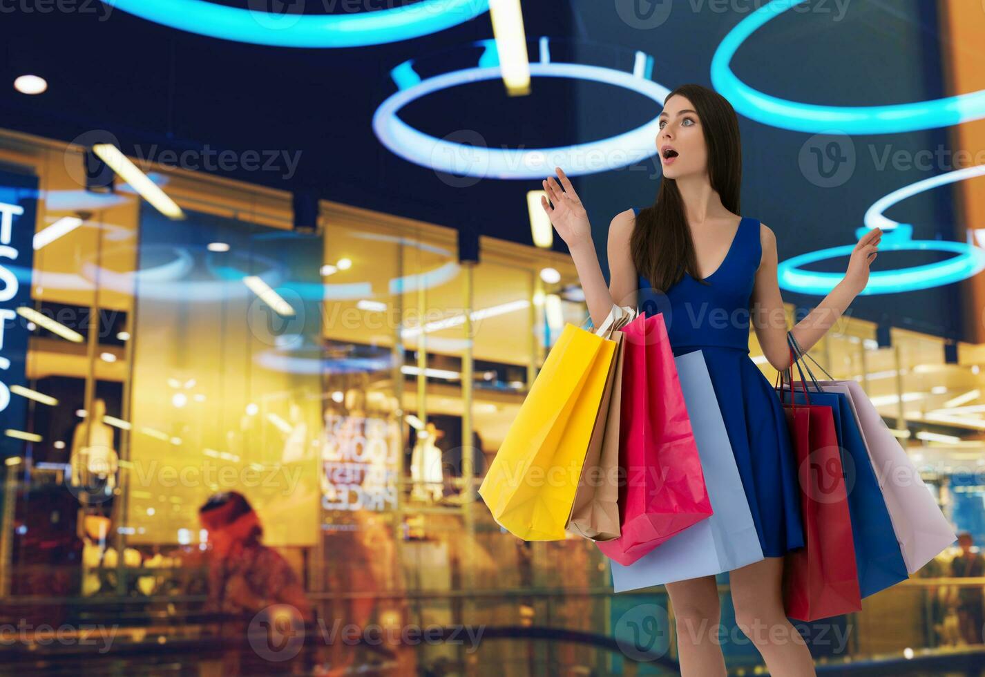 Woman with surprised expression and shopping bags at mall photo