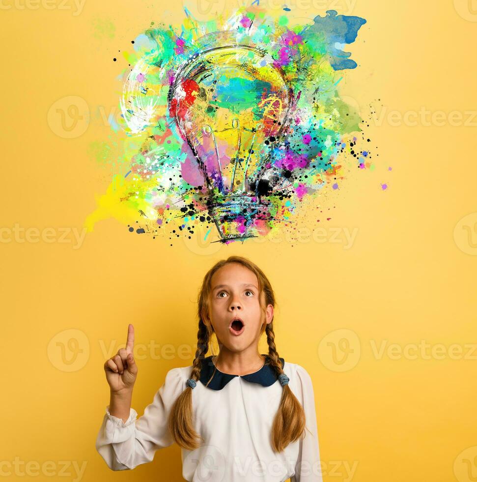 Emotional Child have a big idea. Surprised and amazed face expression. Yellow background photo