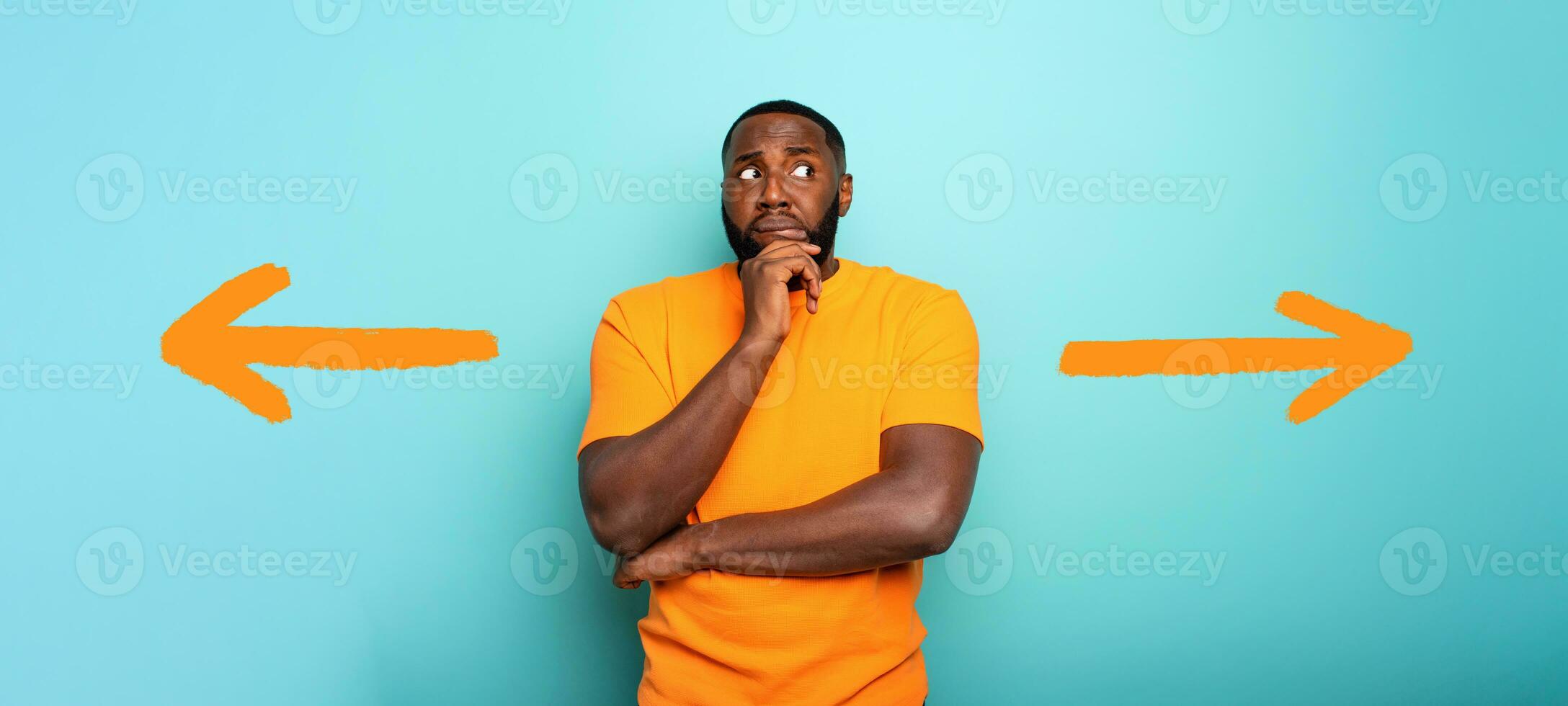 Confuse and pensive expression of a boy with right or left to choose. cyan colored background photo