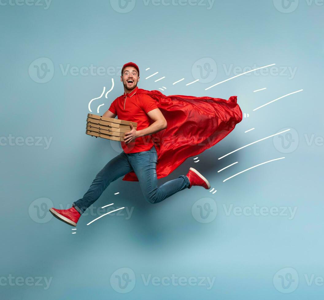 Deliveryman with pizzas acts like a powerful superhero. Concept of success and guarantee on shipment. Studio cyan background photo