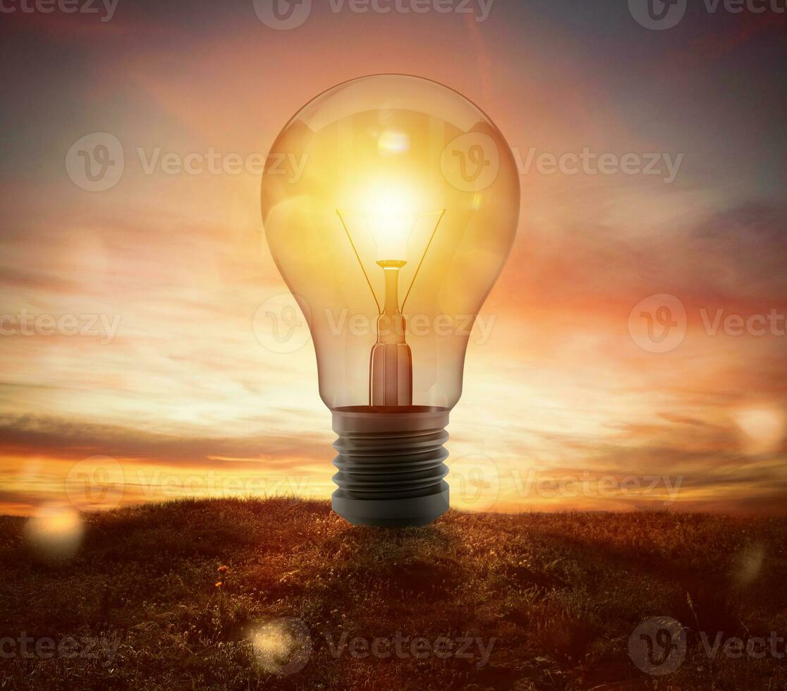 Big lightbulb in a field during the sunset ads concept of idea photo